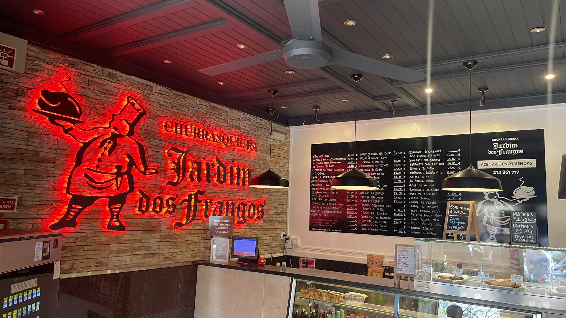 Restaurant counter with neon grill-house signage and menu board